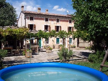 La maison de ferme avec la cour, et la piscine pour des enfants