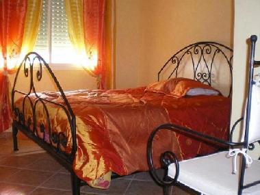 Chambre orange avec placard et volet roulant