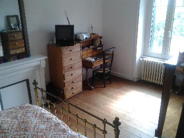 Grande chambre parents avec lit de 140cm et coin bureau.