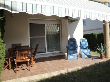 terrasse avec store, mobilier de jardin et chaises relax