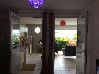 Vue sur cuisine et terrasse depuis le salon quand tout est ouvert